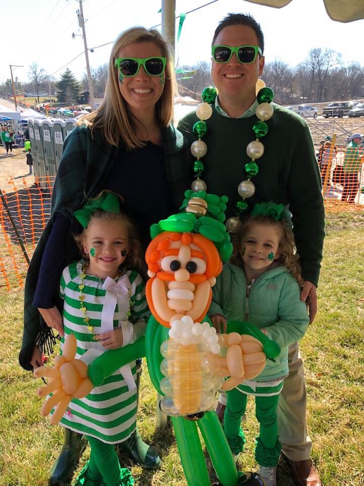 Family with elaborate leprechaun balloon at St. Patrick's Day festival