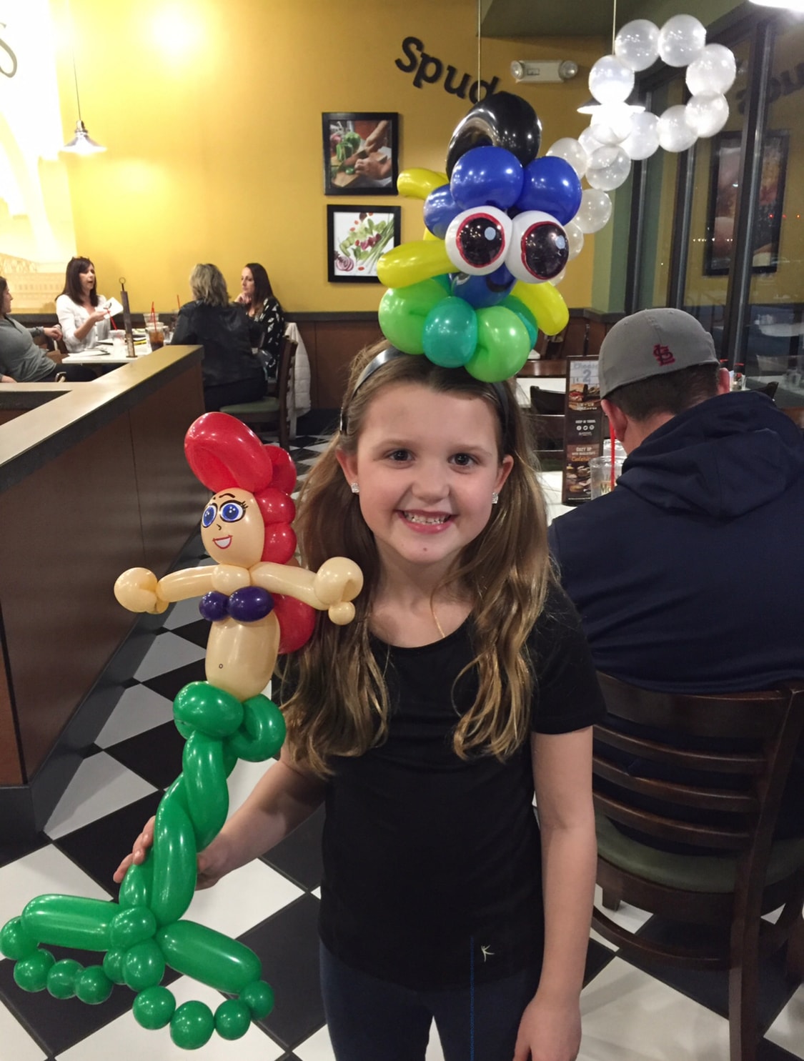 Girl at restaurant with balloon hat and mermaid creation